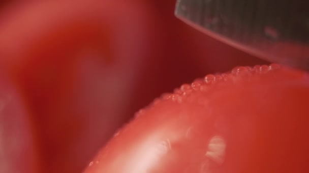 Cięcie pięknych czerwonych pomidorów za pomocą noża kuchennego, krople wody makro wideo. Świeże mokre zdrowe pomidory do jedzenia i gotowania z gospodarstw ekologicznych - Materiał filmowy, wideo