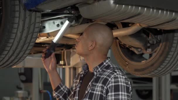 Joven africano examinando su automóvil en el taller - Imágenes, Vídeo