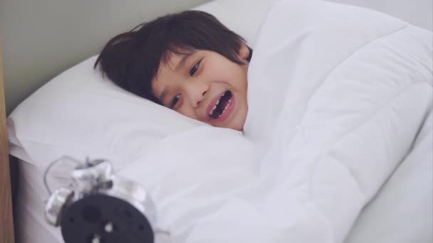 Asiático menino acordar com expressão chocante depois de olhar para tarde despertador em sua cama. - Filmagem, Vídeo