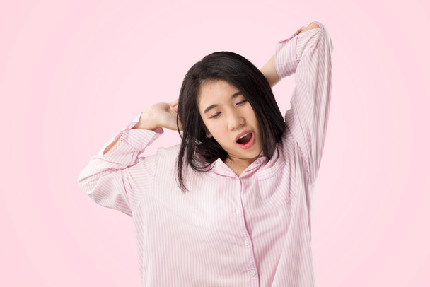 młody Azji kobieta nosić różowy piżama ziew i rozciągnąć kiedy jej obudzić się uczucie senny - Zdjęcie, obraz