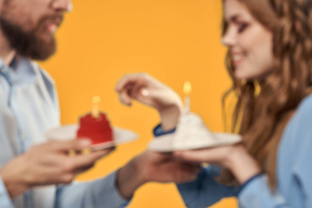Szczęśliwy mężczyzna i kobieta z tort urodzinowy na żółtym tle - Zdjęcie, obraz
