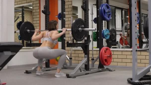 Fit vrouw kraken met lange halter in de sportschool - Video