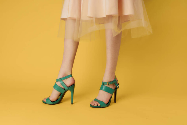 Mujeres piernas zapatos verdes zapatos de moda fondo amarillo - Foto, Imagen