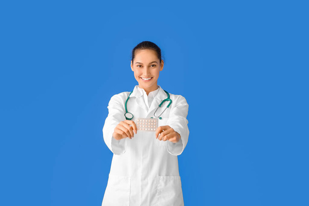 Arzt mit Pillen auf farbigem Hintergrund - Foto, Bild