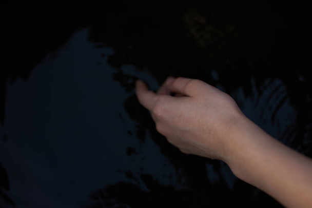 żeńskie ręce na ciemnym tle przezroczysta woda rzeka natura świeże powietrze - Zdjęcie, obraz