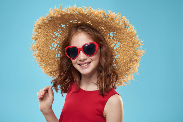 Girl in a beach Straw hat in sunglasses curly hair fun blue background - Valokuva, kuva