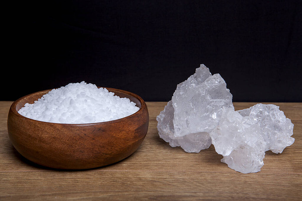 Coarse granules of natural rock or sea salt on old  wooden table and in a bowl on a rustic. - Photo, Image