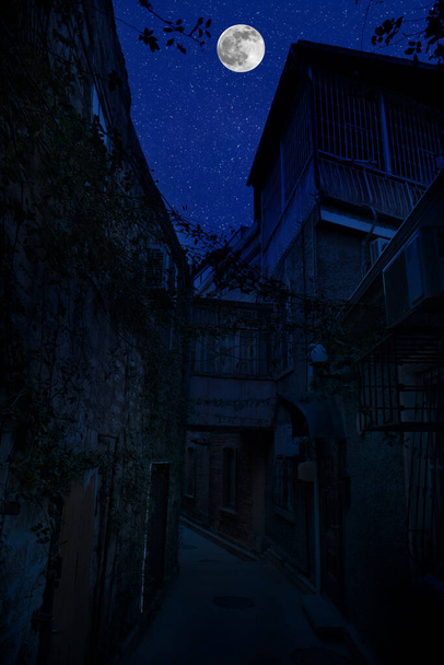 Les rues de la vieille ville la nuit. Pleine lune au-dessus de la ville la nuit, Bakou Azerbaïdjan. Grande pleine lune brillante sur les bâtiments - Photo, image