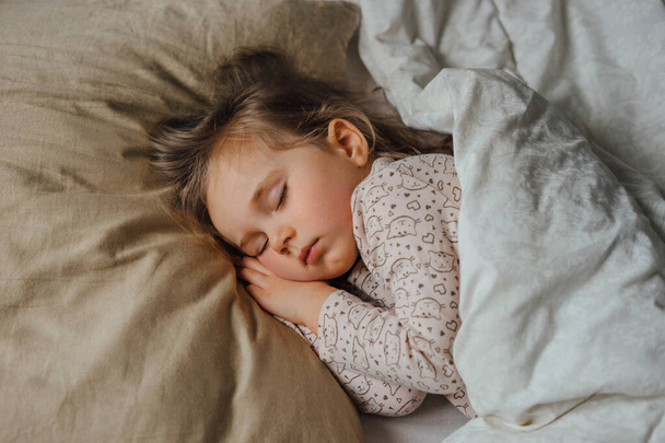 Bambina che dorme a letto a casa, vista dall'alto - Foto, immagini