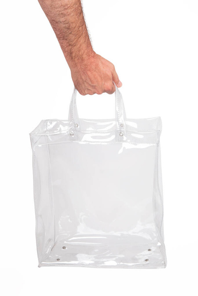Main humaine avec sac en plastique transparent, isolé sur blanc. - Photo, image