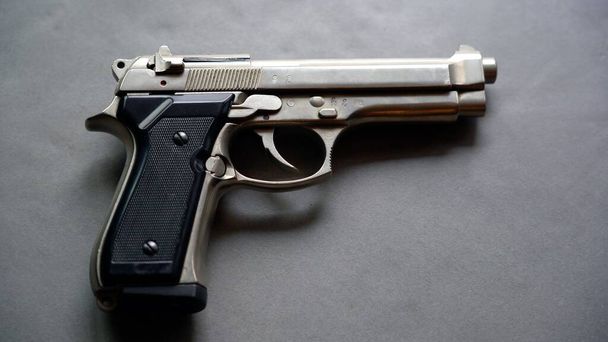  Пистолет, лежащий на столе  - Фото, изображение