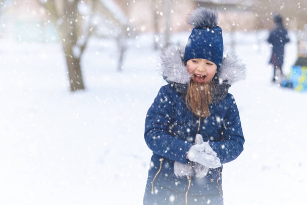 κορίτσι παιδί παίζει με το χιόνι το χειμώνα υπαίθρια και να διασκεδάζουν σε χιονισμένο χειμώνα - Φωτογραφία, εικόνα