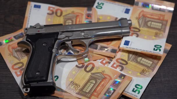  metraje de la pistola colocada sobre la mesa con billetes en euros  - Metraje, vídeo