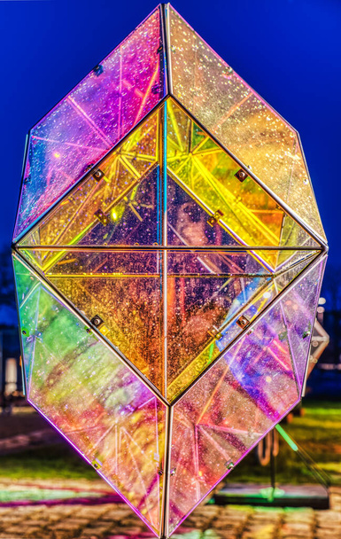 Instalación de luz multicolor acristalada en forma de diamante o rombo con gotas de agua en el vidrio juega una brillante interacción de luces y oscuridad que representa cómo la iluminación afecta a los seres humanos en invierno. - Foto, imagen