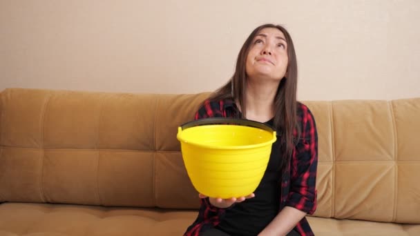 Surullinen nainen kerää vettä virtaa alas katosta sohvalla - Materiaali, video