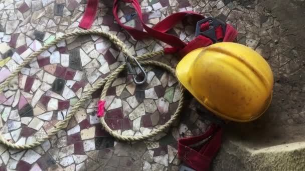 Яскравий жовтий промисловий шолом утримувався на мотузці безпеки для будівельника Локграма - Кадри, відео