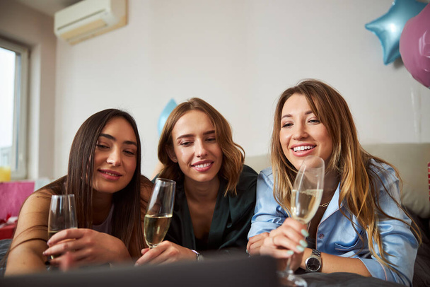 Три счастливые женщины с алкогольными напитками в сети - Фото, изображение