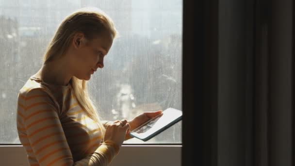 Mujer con portátil junto a la ventana
 - Imágenes, Vídeo