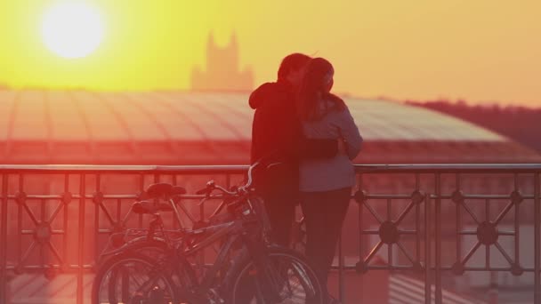 ζευγάρι απολαμβάνοντας το μαγευτικό ηλιοβασίλεμα στην πόλη - Πλάνα, βίντεο