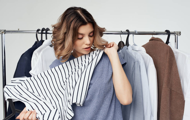 woman chooses clothes on a hanger wardrobe fashion style light background - Fotografie, Obrázek