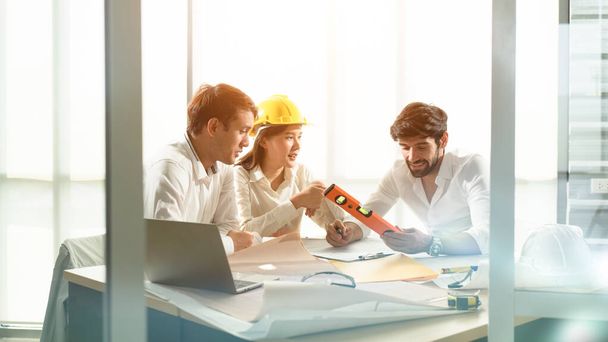 Discussion scene of engineers, house architect, construction engineers in the sunlight meeting room with the blueprint and construction tools, concept of engineering tools, professional teamwork. - Photo, Image