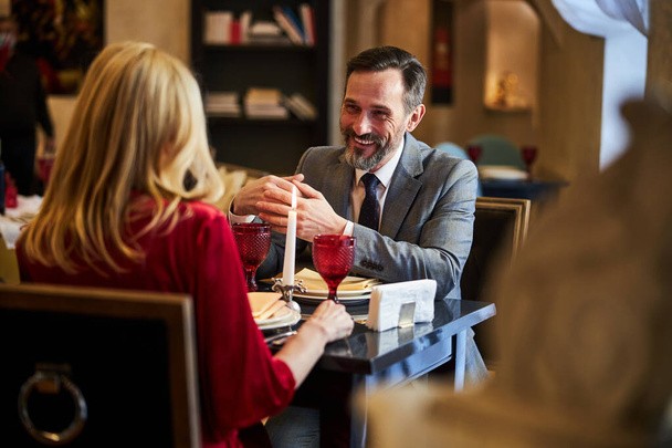 Piacevole gentiluomo godendo della compagnia di una signora affascinante al ristorante - Foto, immagini
