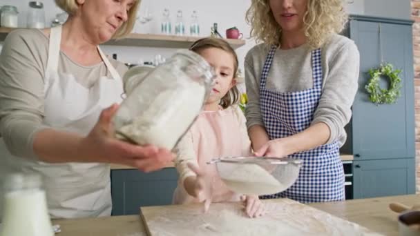 Wideo z małą dziewczynką pomaga przesiewać mąkę. Nakręcony aparatem hel RED w rozdzielczości 8K. - Materiał filmowy, wideo