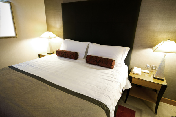 Cama doble en la habitación del hotel
 - Foto, imagen