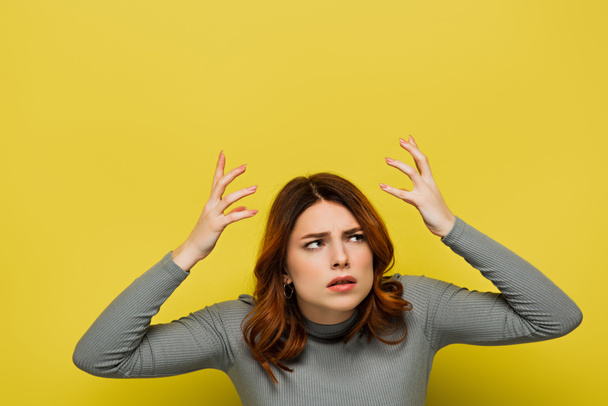 mujer estresada con el pelo rizado gesto aislado en amarillo - Foto, Imagen