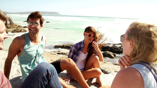 Freunde sitzen auf Felsen am Meer - Filmmaterial, Video