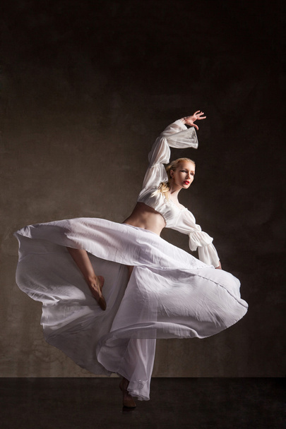 young beautiful dancer posing on gray background - Foto, afbeelding