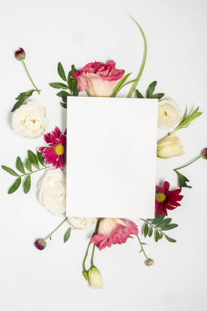 Blumengesteck und leere Karte auf weißem Hintergrund. Muttertag und internationaler Frauentag. Floraler Rahmen und Kopierraum.  - Foto, Bild