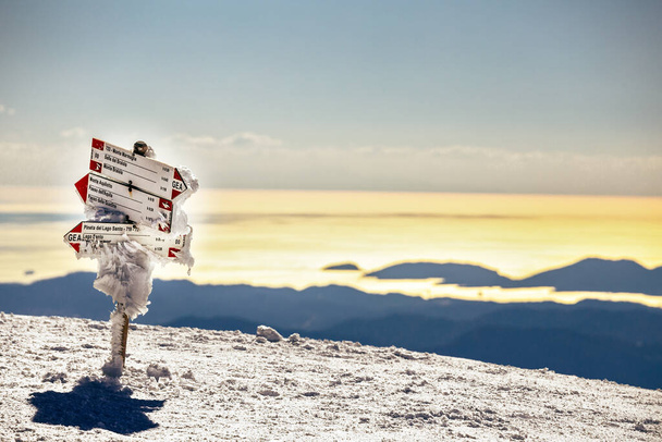 Jäädytetty polku suuntiin merkki lumisella vuorella ja Välimerellä La spezia runoilija Gulf, Italia - Valokuva, kuva