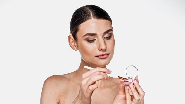 Young adult woman holding eye shadow and cosmetic brush isolated on white - Φωτογραφία, εικόνα