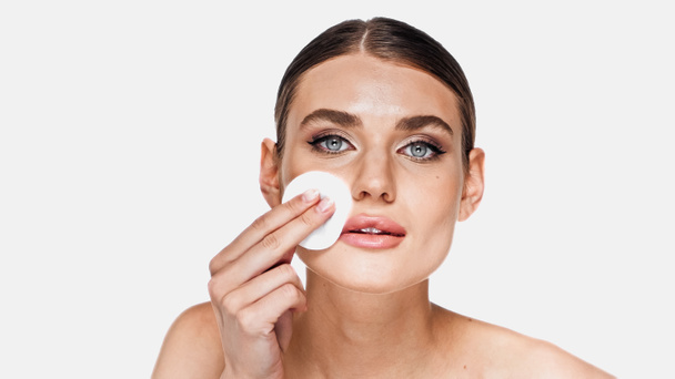 Young woman removing makeup with soft cotton pad isolated on white - Photo, Image