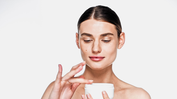 junge Frau hält Glas mit kosmetischer Creme isoliert auf weiß - Foto, Bild