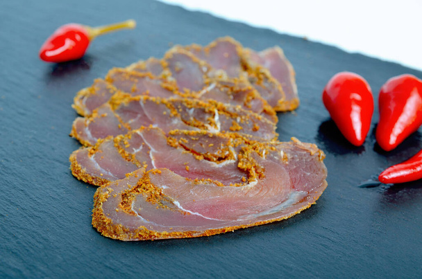 Basturma with pepper on a slate plate mat  - Photo, Image