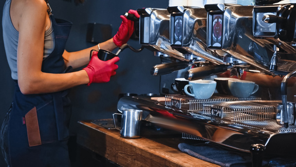 bijgesneden weergave van barista in latex handschoenen met werper in de buurt van stoom wand - Foto, afbeelding