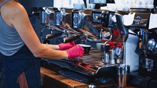 partial view of barista holding cups near modern coffee machine in coffee shop - Photo, Image