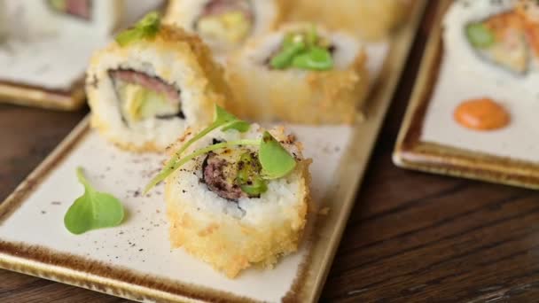 Sushi és szója tekercs fából készült asztalon. Sushi menü. Japán kaja. Koncepció videó élelmiszer luxus japán étteremben - Felvétel, videó