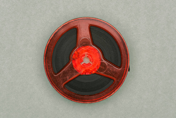 フィルムリール。赤いフィルムと古い丸いスプール。磁性箔。レトロ映画 - 写真・画像