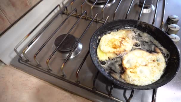 Due uova sono fritte sul fornello su entrambi i lati nel burro in una padella - Filmati, video