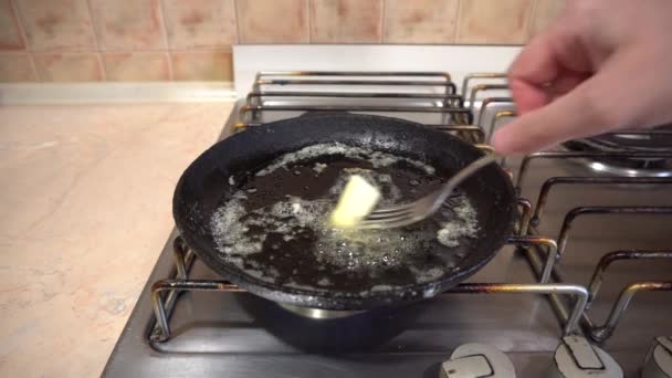 Cucinare le uova in una padella con burro, padella di ghisa su un fornello di casa - Filmati, video