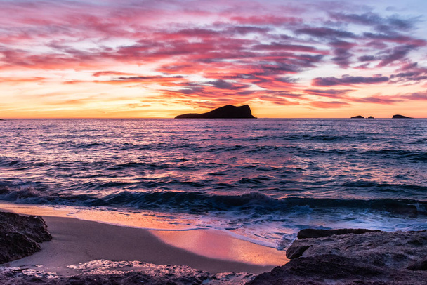 Atardecer purpura en una playa con una isla al fondo - Foto, Imagen