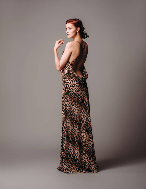 Valentines day look idea. Sexy ginger woman in leopard dress. Womens clothing, fashion concept. Sexy evening gown. Sensual portrait. Natural looking makeup and wavy hair.  - Photo, Image