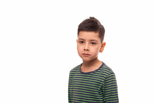 Cintura para cima retrato de um jovem morena menino com um olhar triste sério em um fundo branco - Foto, Imagem