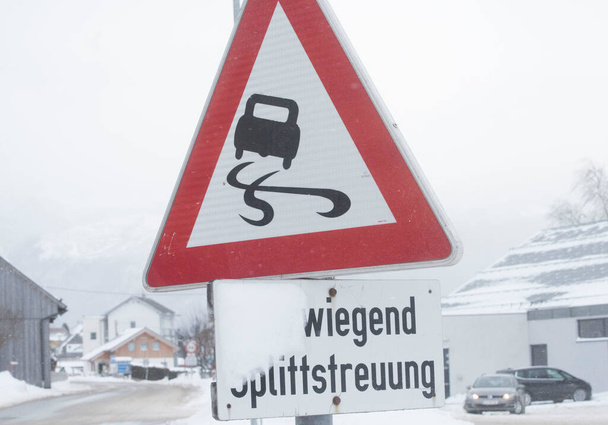 道路交通における警告標識前の注意滑りやすい道路 - 写真・画像