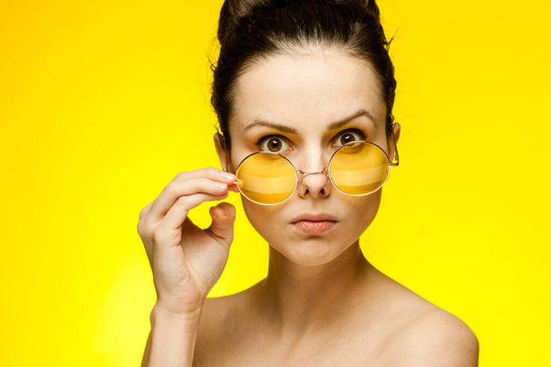 attraente bruna occhiali gialli nudo spalle studio - Foto, immagini