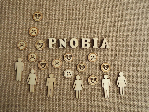enfermedad mental-fobia en forma de letras de madera y figuras de personas sobre un fondo de yute - Foto, Imagen
