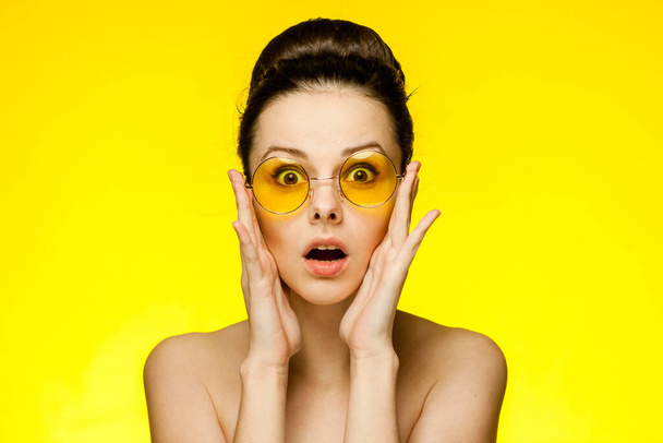 woman with bare shoulders gathered hair clear skin yellow background - Fotó, kép